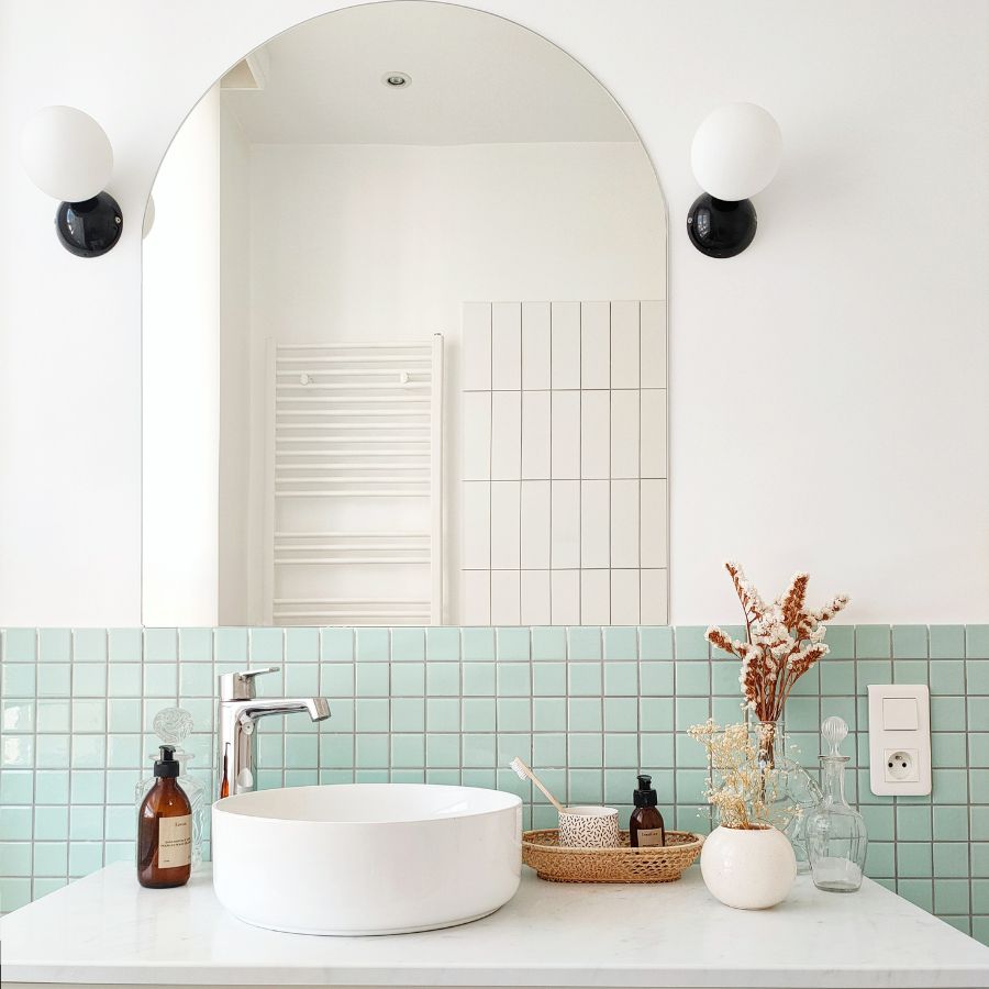 salle de bain avec faience verte et miroir arche